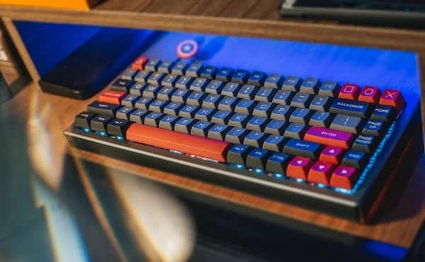 A TKL mechanical keyboard with black PBT keycaps and blue LED backlighting.