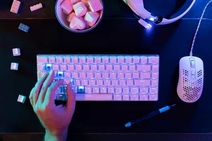 A programmer's workspace featuring a mechanical keyboard, a large monitor, highlighting the essential tools for productive coding.
