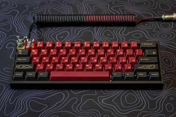 A close-up of a custom keyboard with red and black keycaps.