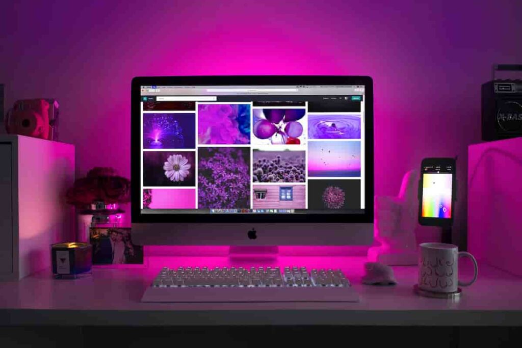 A computer screen emitting a vibrant purple glow, showcasing an ergonomic keyboard and mouse for improved typing in 2024.