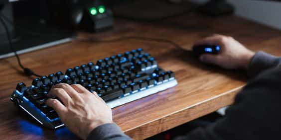 A person typing on a computer keyboard, demonstrating the process of using a keyboard tester to fix keyboard issues.
