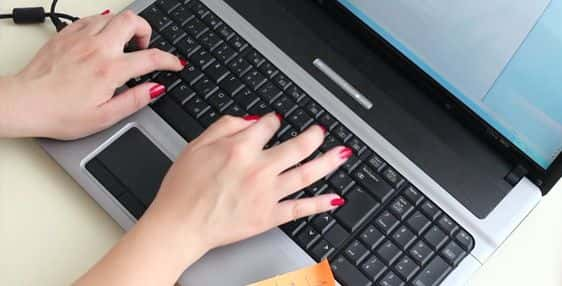 A woman's hands swiftly typing on a laptop keyboard, focused on improving typing speed.


