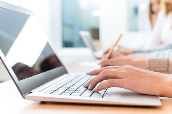 A person typing on a laptop computer, focused and determined to improve their typing speed.


